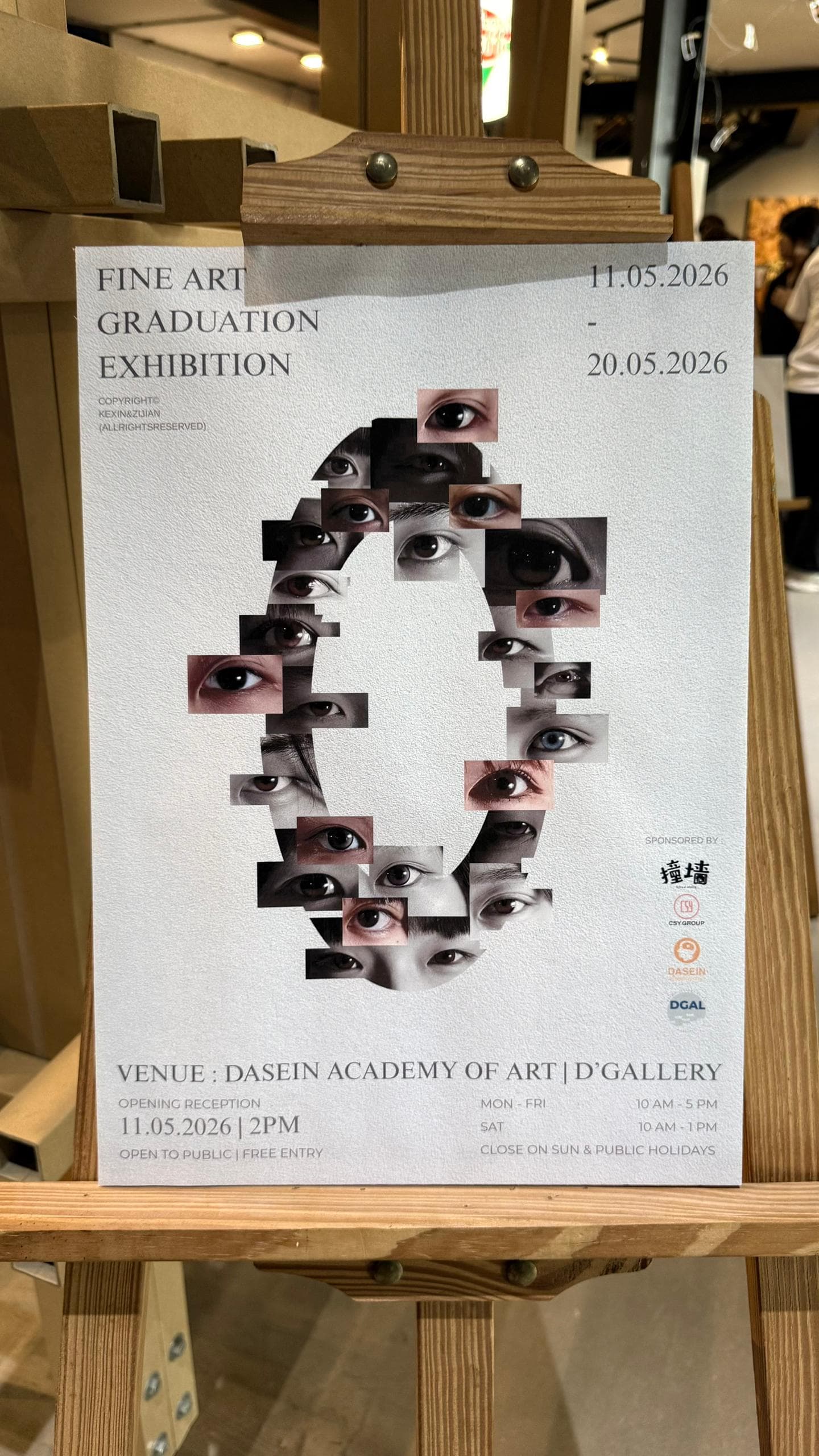 Fine Art Graduation Exhibition poster displayed on an easel